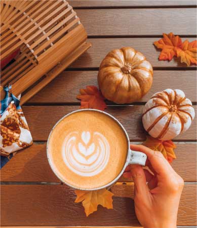 Cup of coffee with pumpkins and leaves