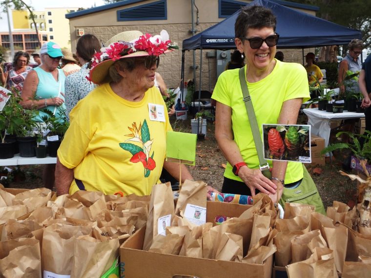 March in the Park 2022 garden club of cape coral members next to calladium bulb table