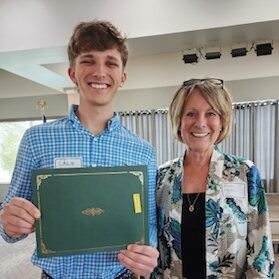 Merit Scholarship winner holding award