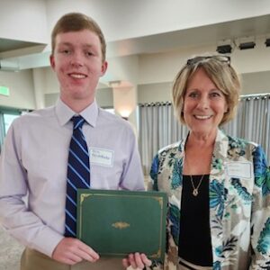 Merit Scholarship winner holding award